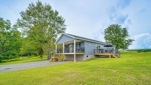 Einbungalow mit Veranda, Terrasse und überdachter Sitzgelegenheit.