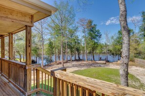 Une terrasse en bois offrant une vue sur un lac et des arbres.