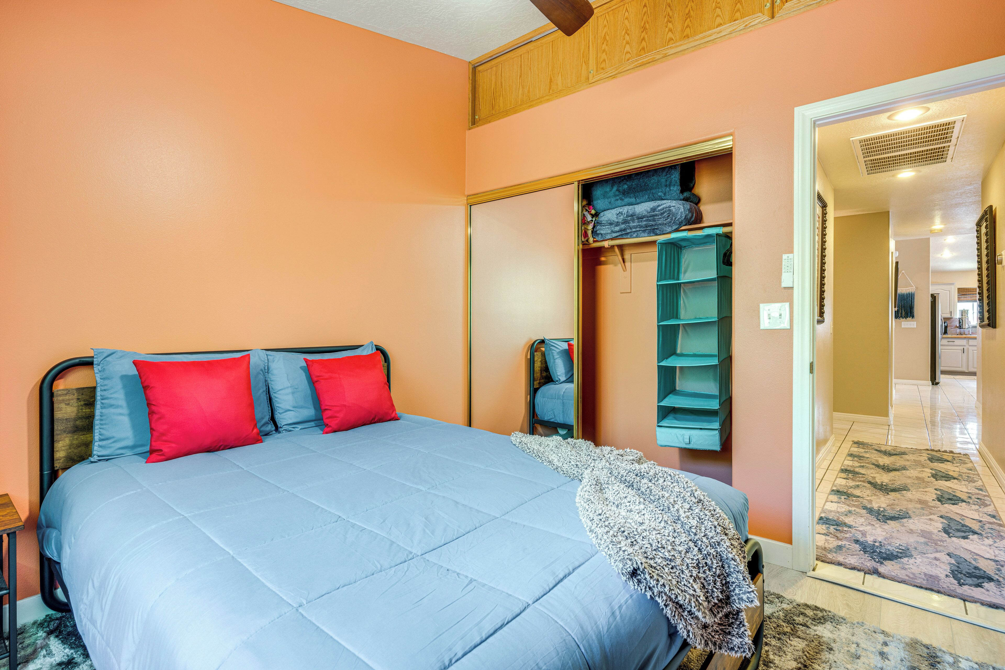 A bedroom with a bed, a wardrobe, and a mirror.