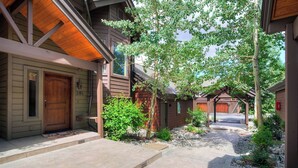 Une maison en bois avec un porche à l’avant, un garage et un espace extérieur abrité.
