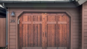 Une grande porte de garage en bois, avec le numéro « 201 » peint sur le mur à gauche.