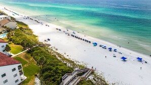 A beach resort with a long stretch of white sand, clear turquoise water, and a wooden boardwalk leading to a building with balconies. - One Second Away|Easy Beach Access|Gulf Views|Private Pool (Santa Rosa Beach)