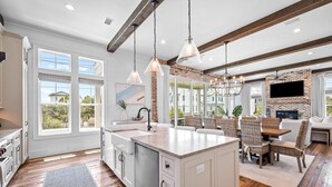 A spacious kitchen with a large island, white cabinetry, and a brick accent wall. - One Second Away|Easy Beach Access|Gulf Views|Private Pool (Santa Rosa Beach)