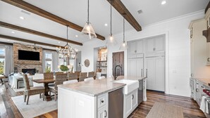 A spacious kitchen with a large island, white cabinetry, and a brick fireplace. - One Second Away|Easy Beach Access|Gulf Views|Private Pool (Santa Rosa Beach)