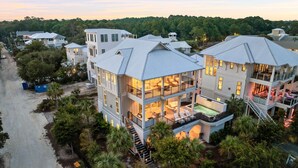 A multi-story residential building with a balcony, a covered outdoor seating area, and a staircase leading to the upper levels. - One Second Away|Easy Beach Access|Gulf Views|Private Pool (Santa Rosa Beach)