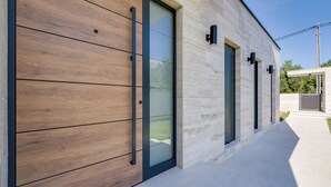 A modern building with a wooden facade, large sliding glass doors, and a clean, minimalist design. - NEW Luxury villa I infinity pool (Starigrad)