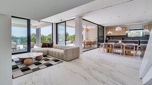 A spacious living area with a large sectional sofa, a round coffee table, and a dining area with wooden furniture. - NEW Luxury villa I infinity pool (Starigrad)
