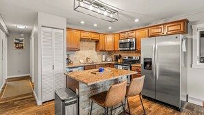 A modern kitchen with wooden cabinets, a stainless steel refrigerator, and a granite countertop. - Best Views in the Valley~Near Skiing~Winter Shuttle (Steamboat Springs)