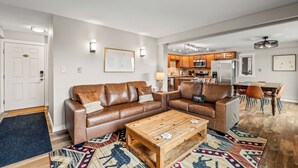 A modern living room with a brown leather sofa, a wooden coffee table, and a patterned rug. - Best Views in the Valley~Near Skiing~Winter Shuttle (Steamboat Springs)