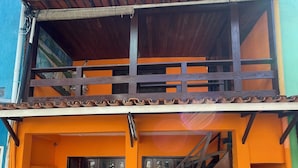 A two-story building with a wooden staircase leading to the upper floor. - Pousada Vila Nova (Cairu)