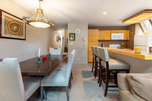 A modern kitchen with wooden cabinets, a microwave, and a refrigerator. - 13 Liftside 3 Bedroom Townhouse by RedAwning (Keystone)
