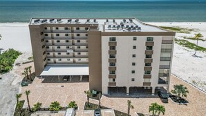 Un hotel de varios pisos con piscina en la azotea y vistas a la playa.