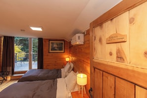 A wooden room with a bed, a nightstand, a lamp, and a sign reading 'Babieca'. - Equs Posada de Campo (San Carlos de Bariloche)