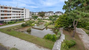A residential area with a well-maintained garden, a pond, and modern apartment buildings. - 500m from the beach, flat for 2 (La Baule-Escoublac)