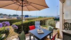 An outdoor patio with a table, chairs, and a large umbrella. - 25m from the beach, seaview, flat for 4 (Erquy)