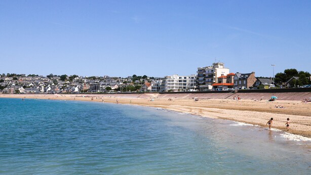 A beach with clear blue water, sandy shore, and buildings in the background. - 25m from the beach, seaview, flat for 4 (Erquy)