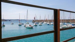 A marina with multiple boats docked, a lighthouse in the background, and a clear sky. - 25m from the beach, seaview, flat for 4 (Erquy)