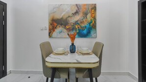 A dining area with a marble table, two chairs, and a centerpiece. - Benetton Apt - Pure elegance (Lekki, Lagos State, Nigeria)