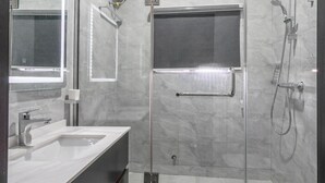 A modern bathroom with a glass-enclosed shower, a large mirror, and a white sink. - Benetton Apt - Pure elegance (Lekki, Lagos State, Nigeria)