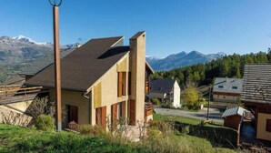 Une maison moderne avec un toit en pente, une façade en bois et un lampadaire en premier plan.