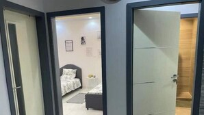 A hotel room with a bed, bedside table, and a small rug. - Appartement Haut Standing à Dakar-résidence Mixta (Dakar)