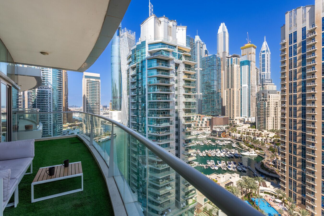 A high-rise building with a view of a marina and other high-rise buildings.