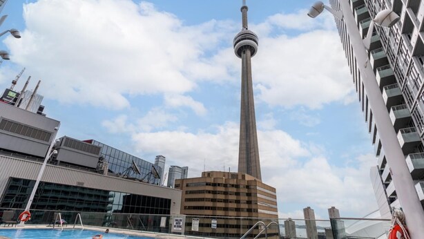 A swimming pool with a view of a tall tower and modern buildings.