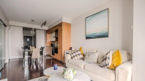 A modern living room with a sofa, coffee table, and a dining area with chairs and a table. - GLOBALSTAY. High Floor 1 Br in the Heart of DT (Toronto/Canada)