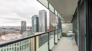 A balcony with a city view, a glass railing, and a small table with chairs. - GLOBALSTAY. High Floor 1 Br in the Heart of DT (Toronto/Canada)