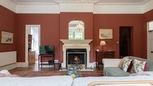 A living room with a fireplace, a chandelier, and a television. - Gorgeous 3BD in Oxfordshire - Stunning Countryside (Steeple Aston)