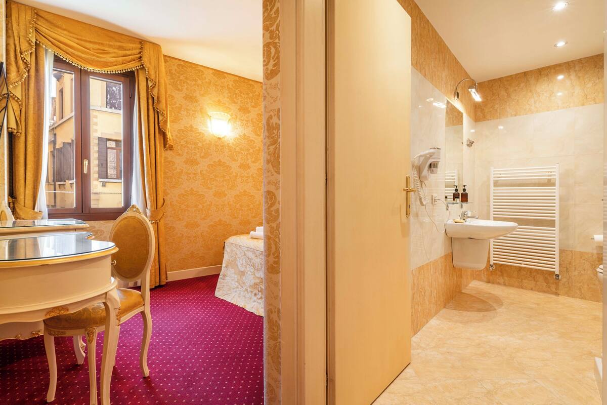 A bathroom with a sink, mirror, and towel rack.