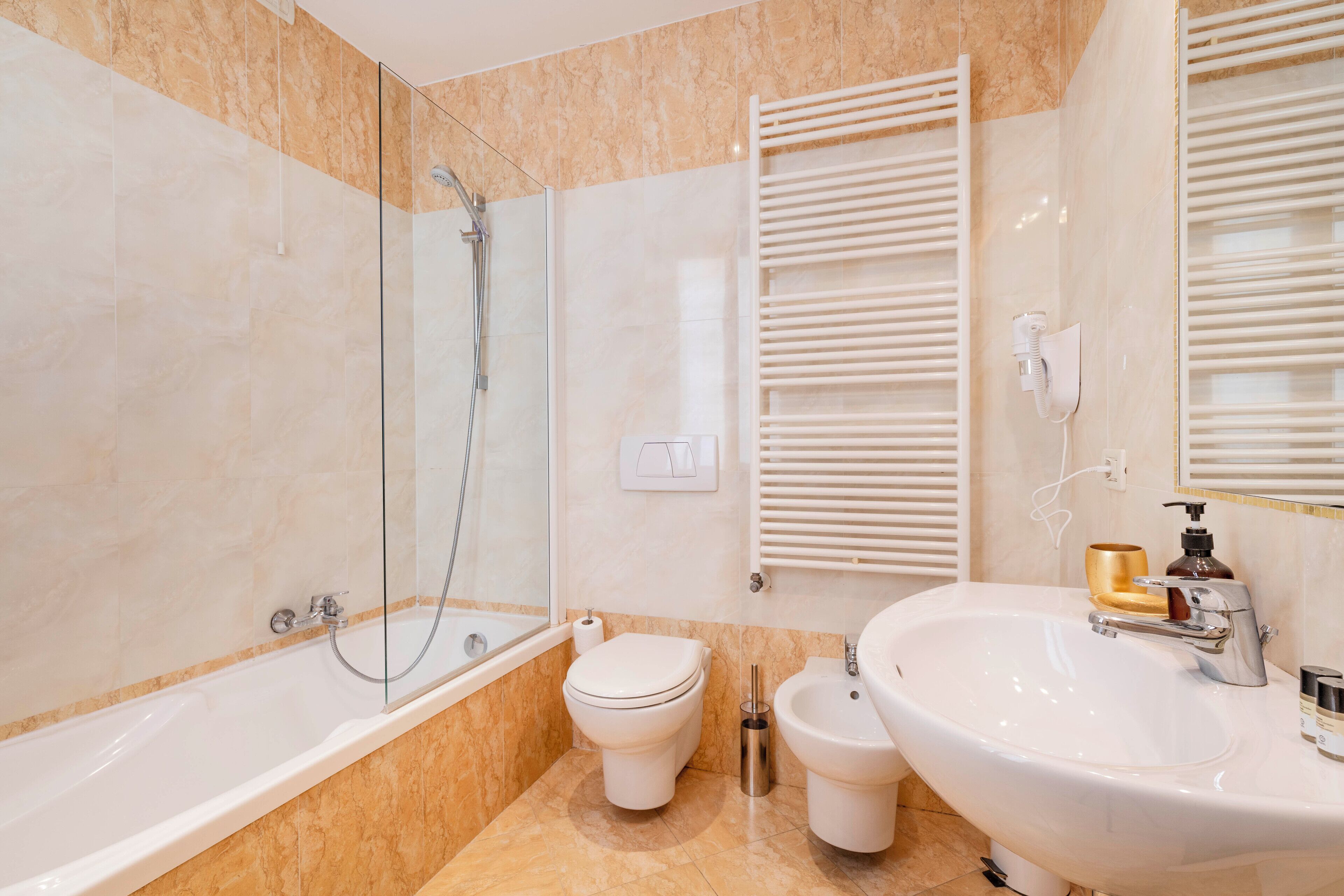 Ein modernes Badezimmer mit Badewanne, Toilette, Bidet und Waschbecken.
