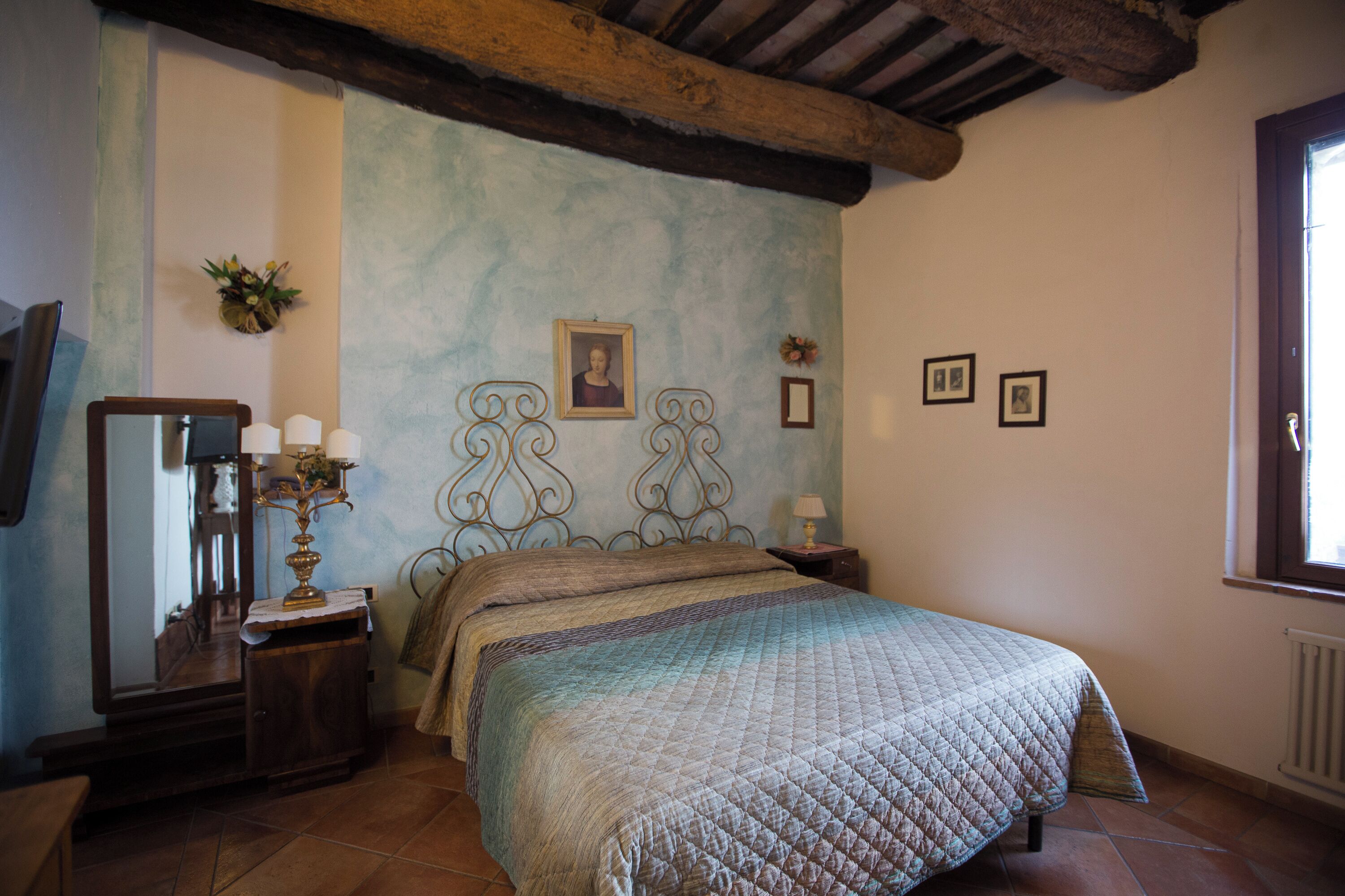 Un dormitorio con cama, cómoda, espejo y ventana.