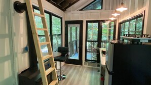 Une cuisine moderne avec une échelle en bois, une cuisinière encastrée et un réfrigérateur.