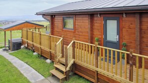A wooden cabin with a porch, steps, and a door. - Stag Lodge - UK46921 (Falkirk)