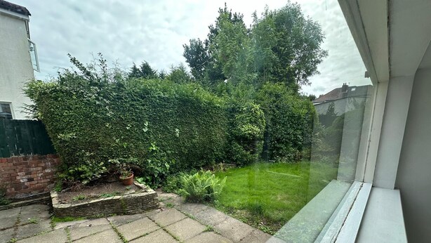 A garden with a paved area and a hedge. - Birmingham Blissful Retreat With 3 Bedrooms (Birmingham)