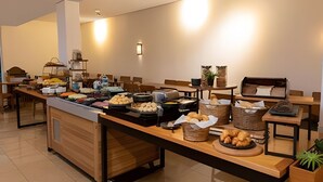 A buffet setup with various food items and a seating area. - Get a Flat 805 Região Jardins SP (São Paulo)