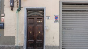 Un edificio con una puerta de madera oscura, una puerta de garaje y un letrero de 'prohibido estacionar'.