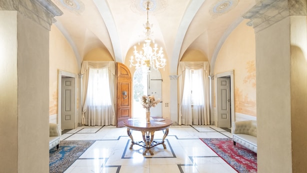 A grand hallway with a chandelier, two sofas, and a table with a vase. - Eighteenth-century Tuscan Villa Tricolle (Fucecchio)