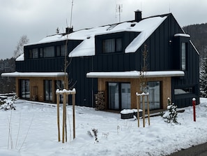 A modern two-story house with a dark exterior, large windows, and a snow-covered roof. - Cerny Dul Kcb045-b1 in Cern Dul (Cerny Dul)
