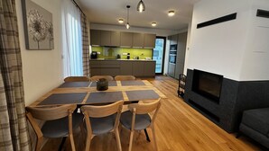 A modern living room with a dining area, a fireplace, and a kitchen in the background. - Cerny Dul Kcb045-b1 in Cern Dul (Cerny Dul)