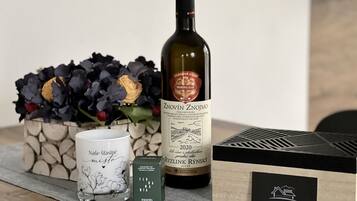 Una botella de vino Znovin Znojmo, una vela aromática y una caja sobre una mesa.