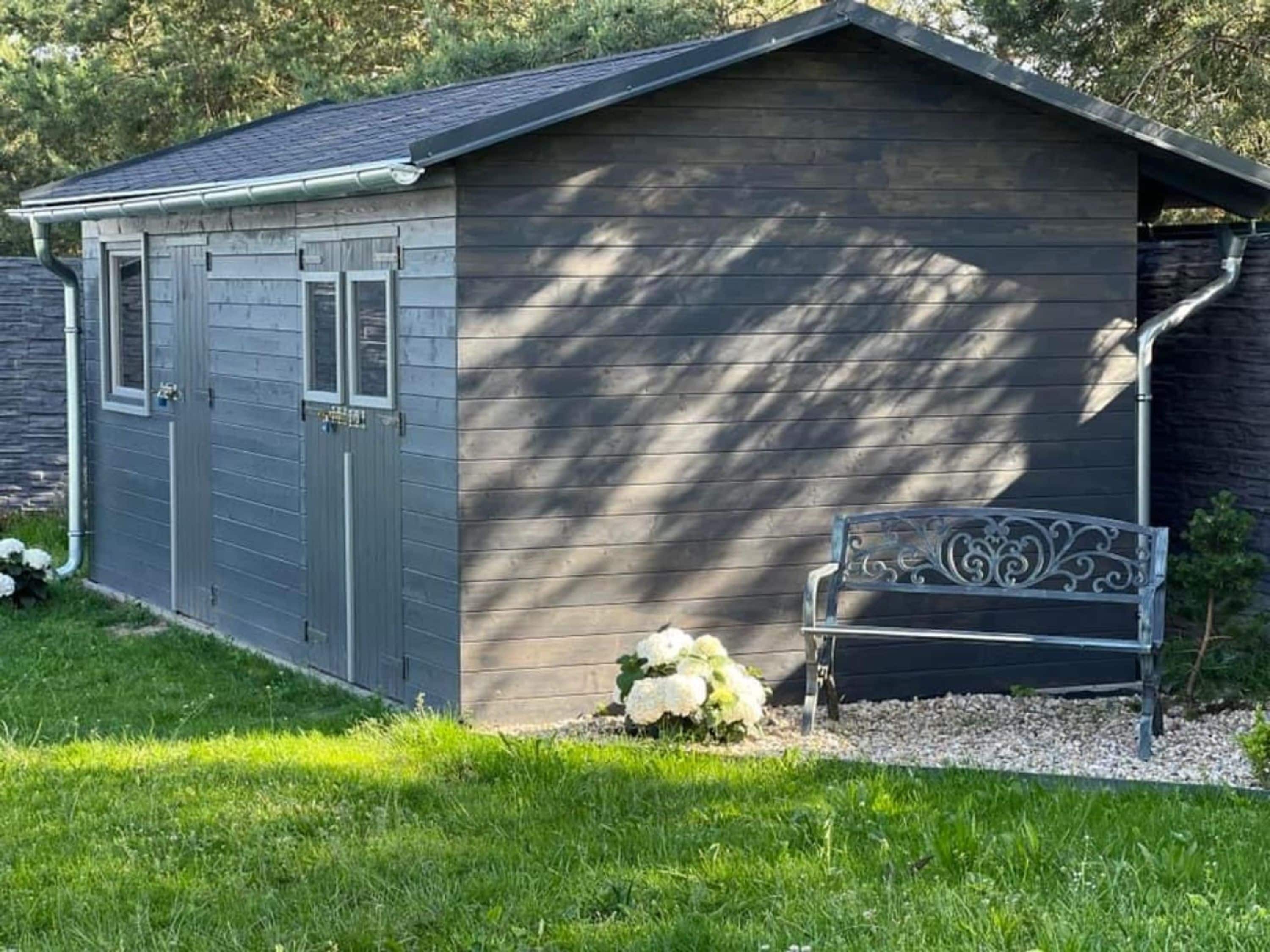 A small, single-story shed with a sloped roof, a door, and a window.