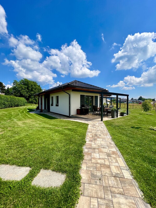 Una casa con patio, césped y cielo despejado.