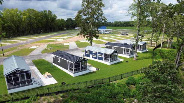 A residential area with modern houses, a paved road, and a fenced green space. - Lake View Cabin, 2 Bedrooms, 13 miles from Jacksonville! (Maysville)