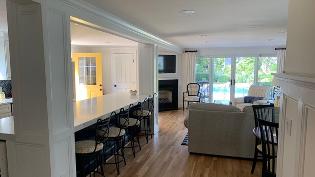 A spacious living area with a large island and bar seating, a fireplace, and a view of a pool. - Spend Commissioning Week Here:  Walk to Yard, Pool, Hot Tub, Kayaks, and more... (Annapolis)