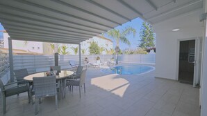 A covered outdoor area with a pool, lounge chairs, and a dining table. - 124 PRO 1 - Stay Villa Prince (Paralimni)