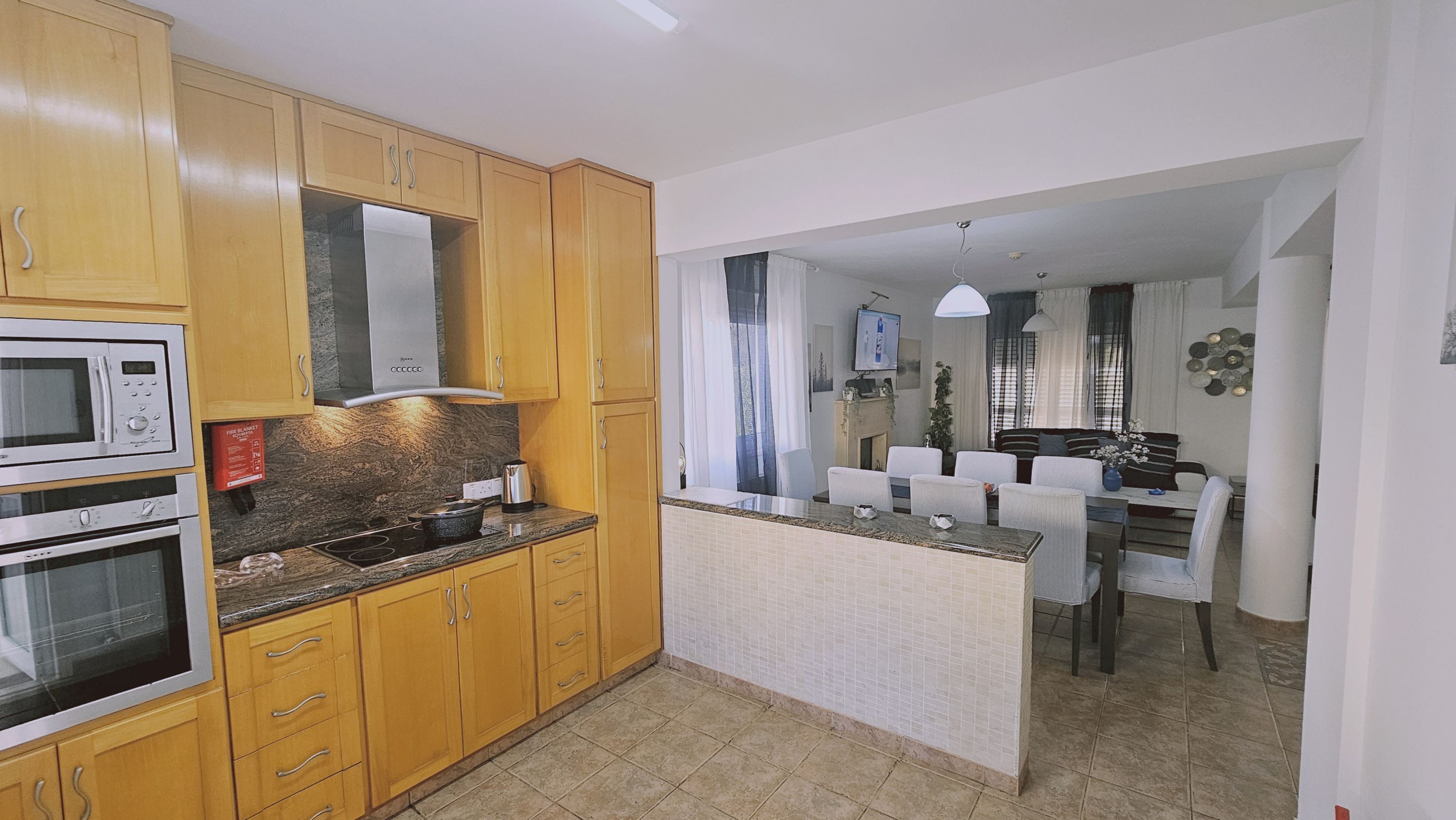 A compact kitchen with wooden cabinets, a built-in microwave, and a stove.