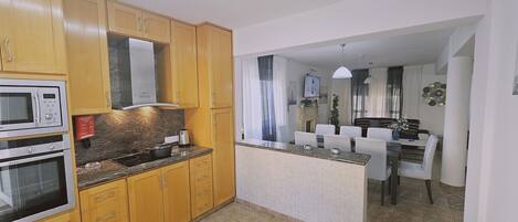 A compact kitchen with wooden cabinets, a built-in microwave, and a stove.