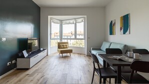 A modern living room with a sofa, a dining table, and a TV. - Italianway Comfort - D Aragona 2 (Milan)